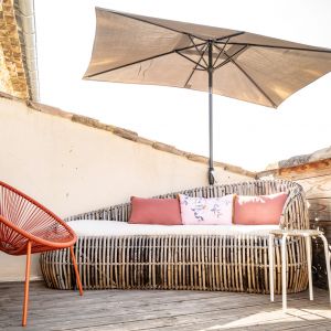 Heerlijk privé-terras met loungebank, zitstoel, parasol en eetset
